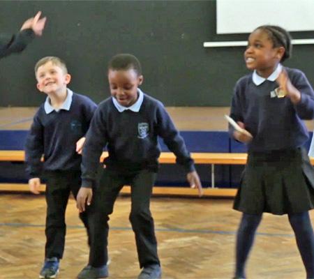 Happy primary school children moving to music