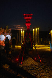 Photo of Warning Notes - a red siren and large hanging copper strips.