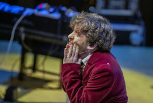 Martin Green with his hands to his face, on stage
