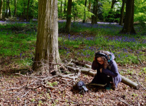 Photo of Gwen Siôn with headphones in the forest
