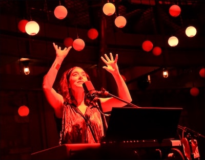 Roxana Vilk performing with keyboard and microphone