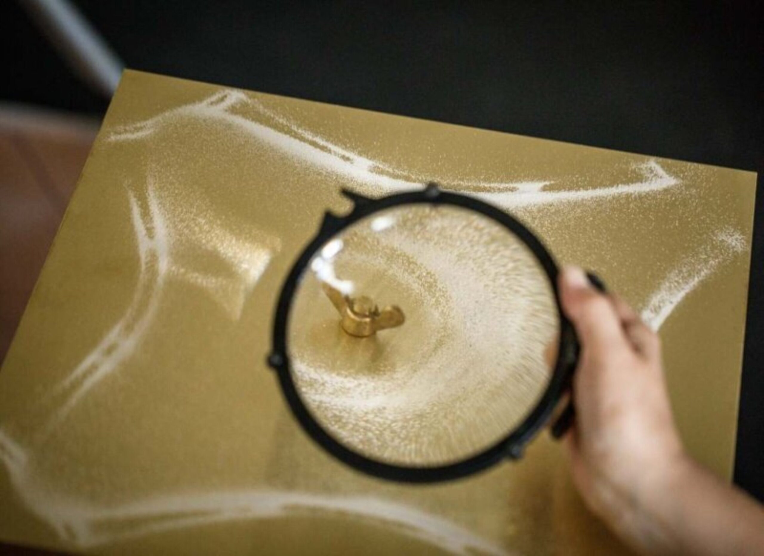 Metallic plate with wing nut and white powder arranged in a pattern