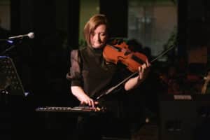Ellie Wilson plays her violin whilst using her live colour midi pad
