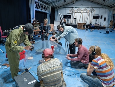 People seated on the floor around a transparent sphere