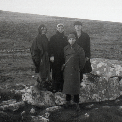 Grainy black and white photo of four members of Goblin Band outside with rocks