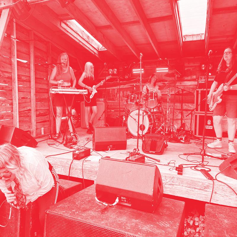 Red image of Rainham Sheds onstage with instruments